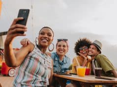 Group of friends at table taking selfie