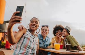 Group of friends at table taking selfie
