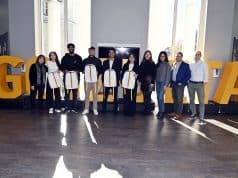 Team Charlie standing in front of Goizueta letters with Goizueta Faculty and UPS Judges