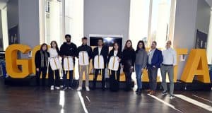 Team Charlie standing in front of Goizueta letters with Goizueta Faculty and UPS Judges